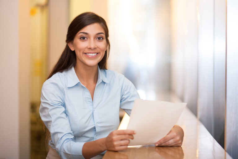 Confident businesspeople standing outside office building with laptop